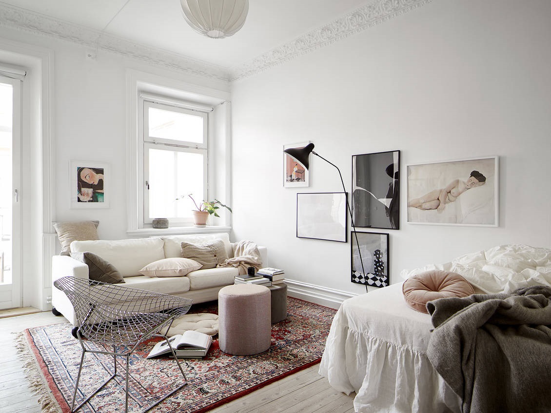 an airy and chic Parisian studio apartment done with a colorful print rug and a stylish gallery wall