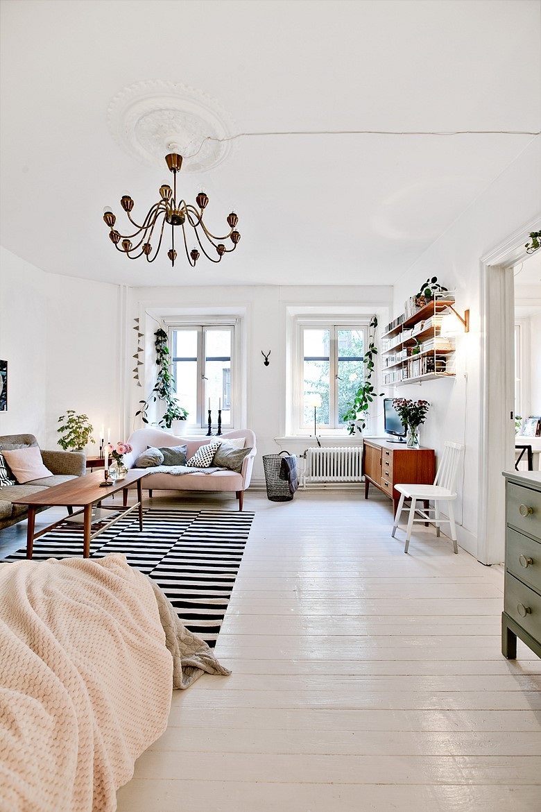 a welcoming and airy studio apartment done in neutrals and pastels with just a bit of black for eye-catchiness