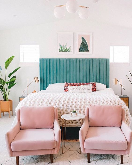 a stylish bed with a pretty mint green channel tufted headboard contrasts the chairs and looks wow