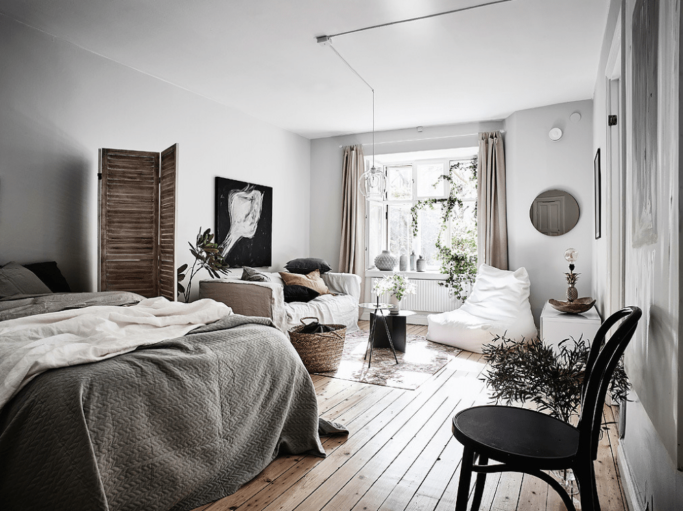 a Nordic studio apartment with a sleeping zone separates with a wooden screen from the rest of the space