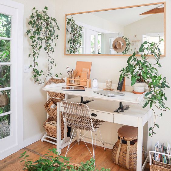 a small and neutral boho home office with baskets and basket boxes, with climbing plants to enliven the space