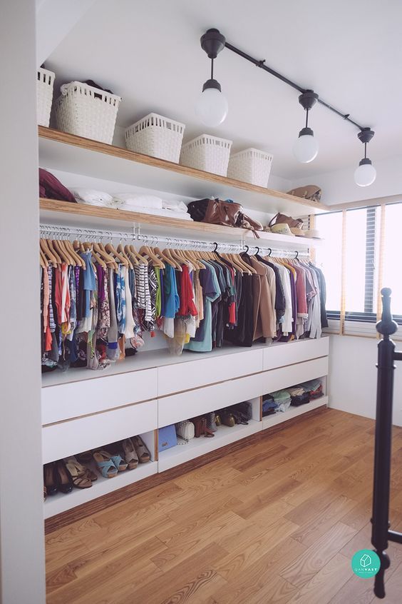 a welcoming contemporary closet with a long holder, open shelves for storing things and boxes, open storage compartments for shoes and drawers