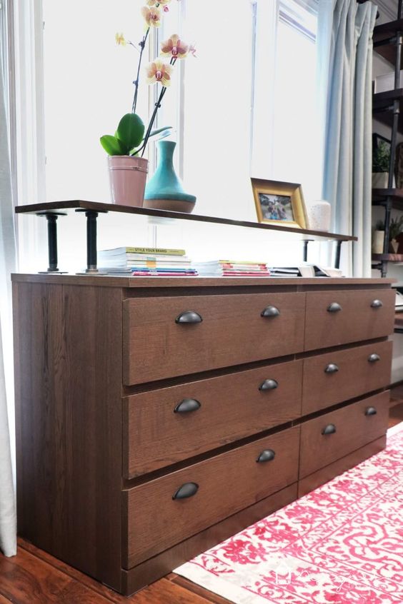 an IKEA Malm dresser turned into a console table with a raised countertop, rich strain and vintage pulls
