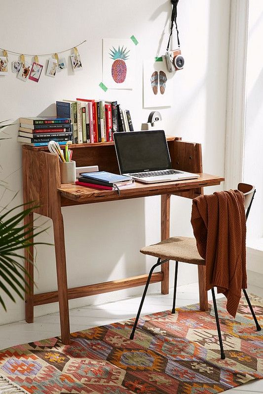 a modern workspace with a stained desk, a comfy chair, some books, photos, art and a camera is lovely and cool