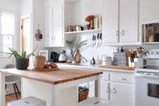 a modern white kitchen with butcherblock countertops, a kitchen island with a breakfast bar, white stools