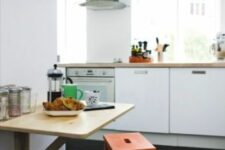 a stylish modern kitchen with sleek white cabinets, a wall-mounted breakfast bar, an orange ladder and pendant lamps