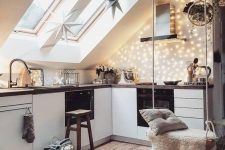 a Scandinavian attic kitchen with sleek white cabinetry, dark stained countertops, lights, stars and a swing for a dreamy touch