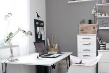 a Scandinavian space with white and grey walls, white furniture, black bedding, a shelving unit, a lovely workspace by the window