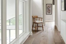 a chic space with an arched doorway, laminate floors and a vintage chair plus much natural light coming through windows