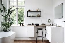 a contemporary bathroom with white walls and dark stained parquet flooring, a white vanity and a white oval tub