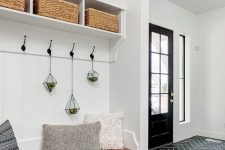 a farmhouse entryway with white walls, a navy tile floor and a lovely built-in storage unit with baskets is a very cool idea