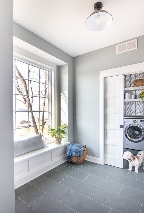 a laundry room with grey walls and a grey tile floor, a windowsill bench and a sliding door is a very cool and simple idea