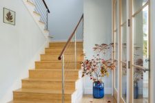 a lovely and welcoming entrance with bamboo floors and a staircase clad with the same bamboo to make the space more cohesive