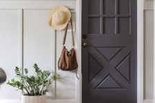 a lovely entryway with a grey door, a vinyl floor, a potted plant, a hat and some stuff looks chic and elegant