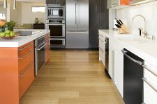 a mid-century modern kitchen with bamboo flooring, an orange kitchen island and metal items and touches is cool