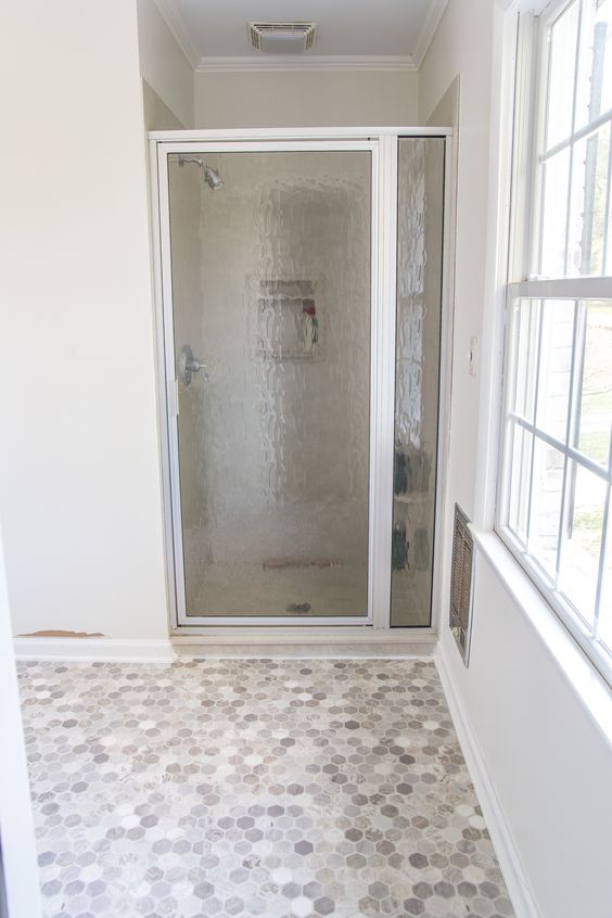 a small neutral bathroom with a shower space, a marble penny tile vinyl floor is a lovely and chic space to be