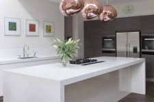 a sophisticated white kitchen with dark parquet floors, sleke white cabinets, grey ones with built-in appliances and copper lamps