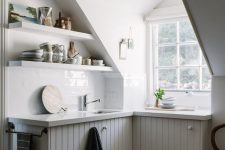 a tiny attic kitchen with a window, planked cabinets, open shelves and a vintage chair is a lovely idea to rock