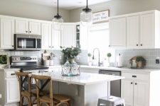 a white farmhouse kitchen with dark laminate floors, a grey subway tiles, pendant lamps and rattan stools is chic and cool