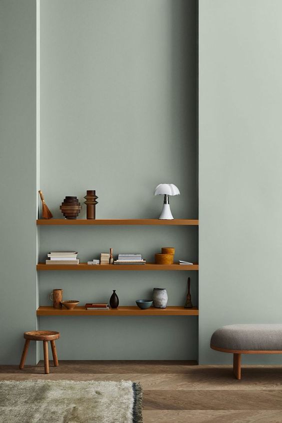 a minimalist space with slate blue walls, built-in shelves and stained and grey furniture is chic and cool