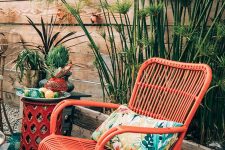 11 a red rattan chair with a colorful pillow and a bold rug, some potted plants for a colorful outdoor space