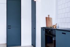 13 a chic minimalist Royal blue kitchen with black built-in appliances and black touches looks amazing