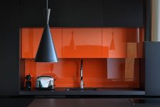 17 a minimalist black kitchen with a sleek orange backsplash and mini cabinets that are a gorgeous color statement in the space