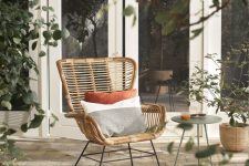 18 a cool rattan chair styled with soft pillows, with a side table and some greenery around is a lovely piece for outdoors
