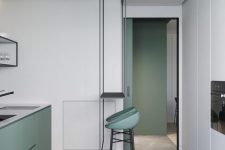 19 a minimalist kitchen with sleek green cabinets, white cabinets and a built-in oven, green stools and black fixtures