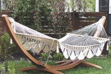 22 a garden space with a large hammock on a stand and printed pillows is a dreamy space to have a nap