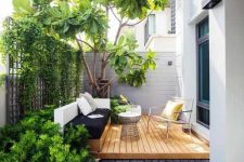 25 a small contemporary backyard with a wooden deck, a built-in daybed and a cool chair, some growing plants and a large living tree