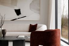 26 a sophisticated minimalist living room with lovely cruved furniture, a statement artwork, a burgundy chai and a black marble table