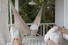 30 a relaxed boho porch with a planked floor, a hammock, a bench with pillows, poufs and macrame is a chic idea