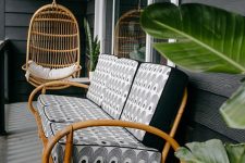 31 a tropical porch with a rattanegg-shaped suspended chair and a rattan sofa with printed cushions plus greenery around