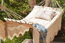 32 a small and cozy outdoor space with a hammock attached to the trees and colorful boho textiles is very welcoming