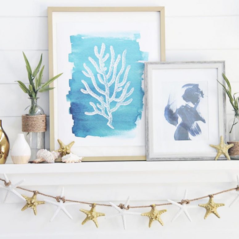 a beachy mantel with a starfish garland, seashells and starfish on it, pretty watercolors and some greenery