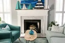 a coastal mantel with a bold sea artwork and several boats doubles as a stand for kids’ artworks and crafts and looks cool