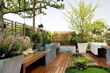 a contemporary rooftop terrace with potted plants and even trees, a wooden deck and concrete and wood furniture