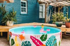 a cool stock tank pool with colorful painted elements for decor and colorful floats is a lovely idea to have in your summer backyard