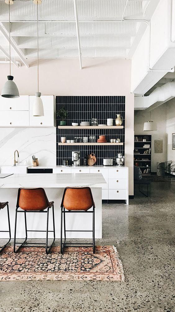 a lovely modern kitchen with a green terrazzo floor and a blush wall, white furniture and a black skinny tile backsplash