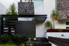 a modern and fresh front yard with stone tiles, with grasses, succulents and some trees inspires and welcomes in