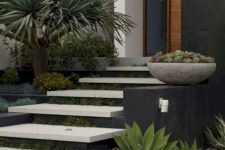 a modern front yard with neutral steps and greenery in between the steps, with trees and succulents around is a chc and bold space