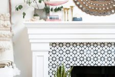 a pretty summer mantel with greenery, a mirror in an ornated frame, gold candleholders and wooden beads is fun