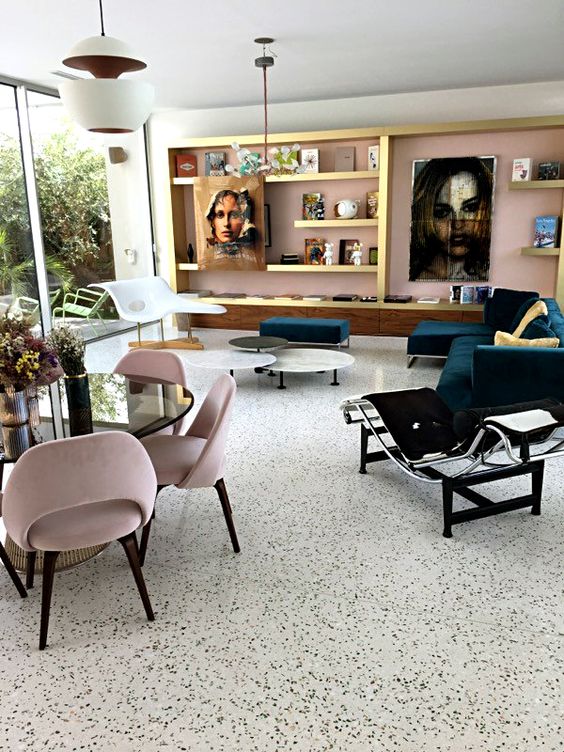 a refined living and dining room with a black and white terrazzo floor, a pink wall and a chic storage unit, statement artworks