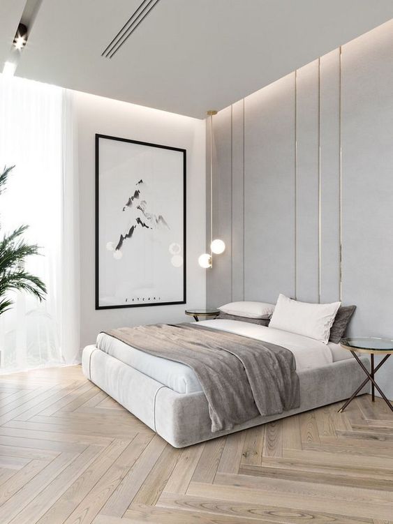 a refined minimalist bedroom in neutrals with an upholstered bed, glass side tables, a statement artwork and built-in lights