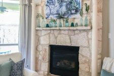 a simple summer mantel with various bottles and jars, with a beautiful blue watercolor over it is cool