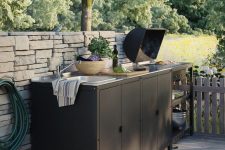 a small black kitchen by IKEA, of black metal cabinets and shelves that are very practical, a grill and a built-in sink