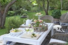 a small deck with a white table and woven chairs is a pretty and cool space to dine outdoors is amazing