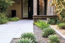 a stylish modern front yard with tiles covering it and succulents and trees is a chic space that welcomes inside