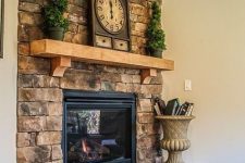 a summer farmhouse mantel with potted mini trees and a vintage clock is a simple and fresh idea for the season